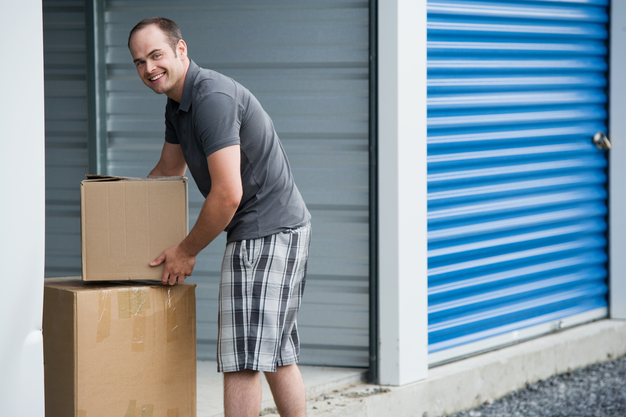 Man-taking-boxes-out-of-an-outdoor-storage-unit